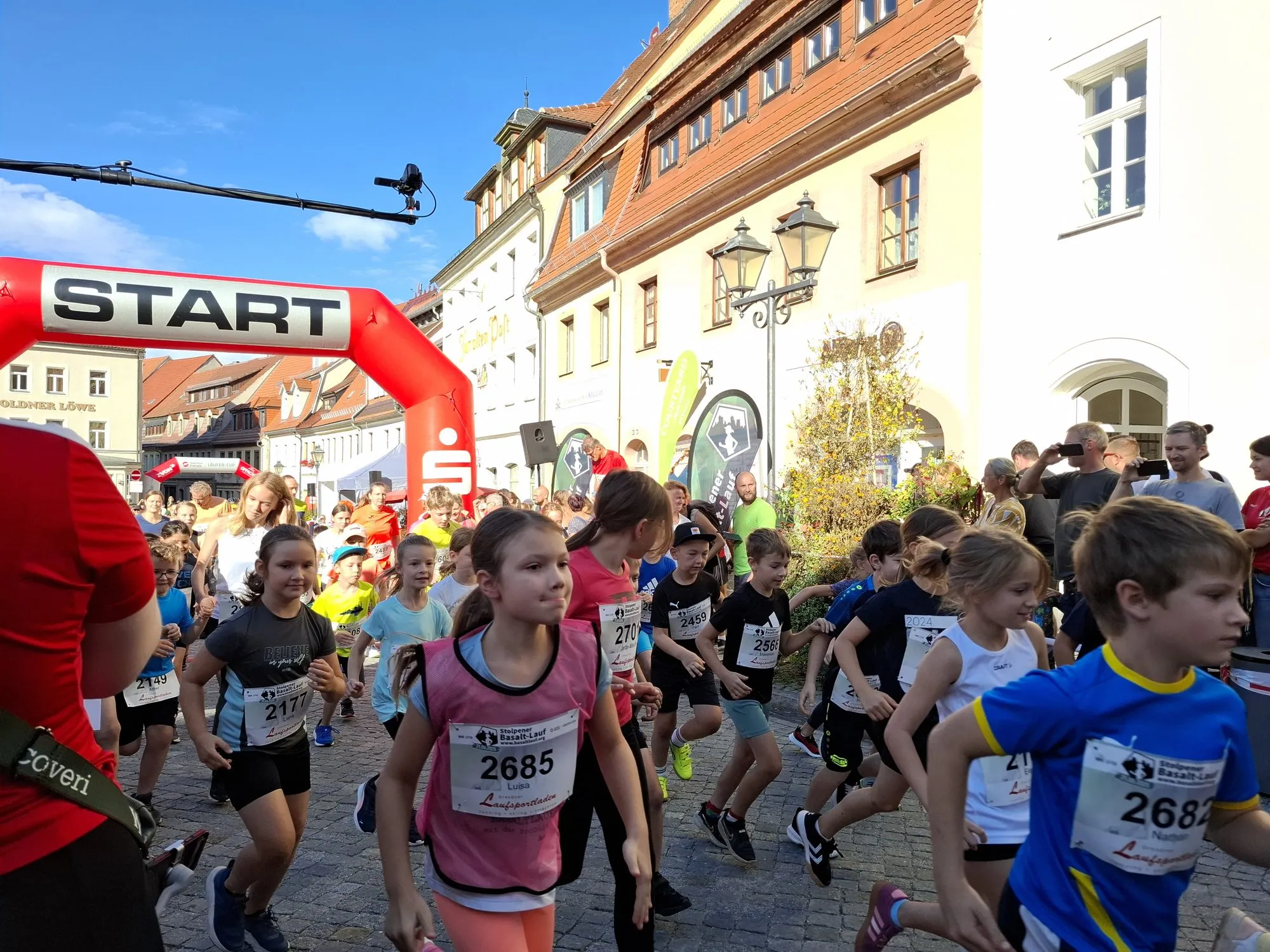 Kinder starten unter dem Startbogen