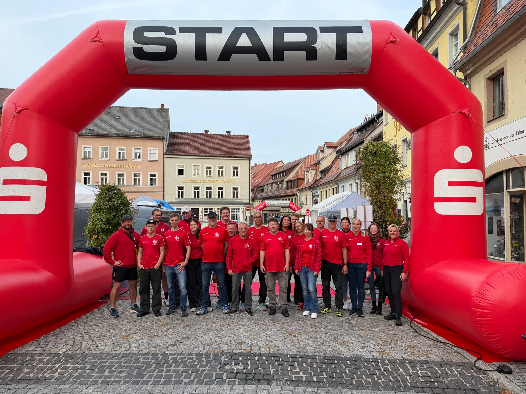 Das Helferteam in roten Basalt-Lauf-Shirts vor dem Startbogen