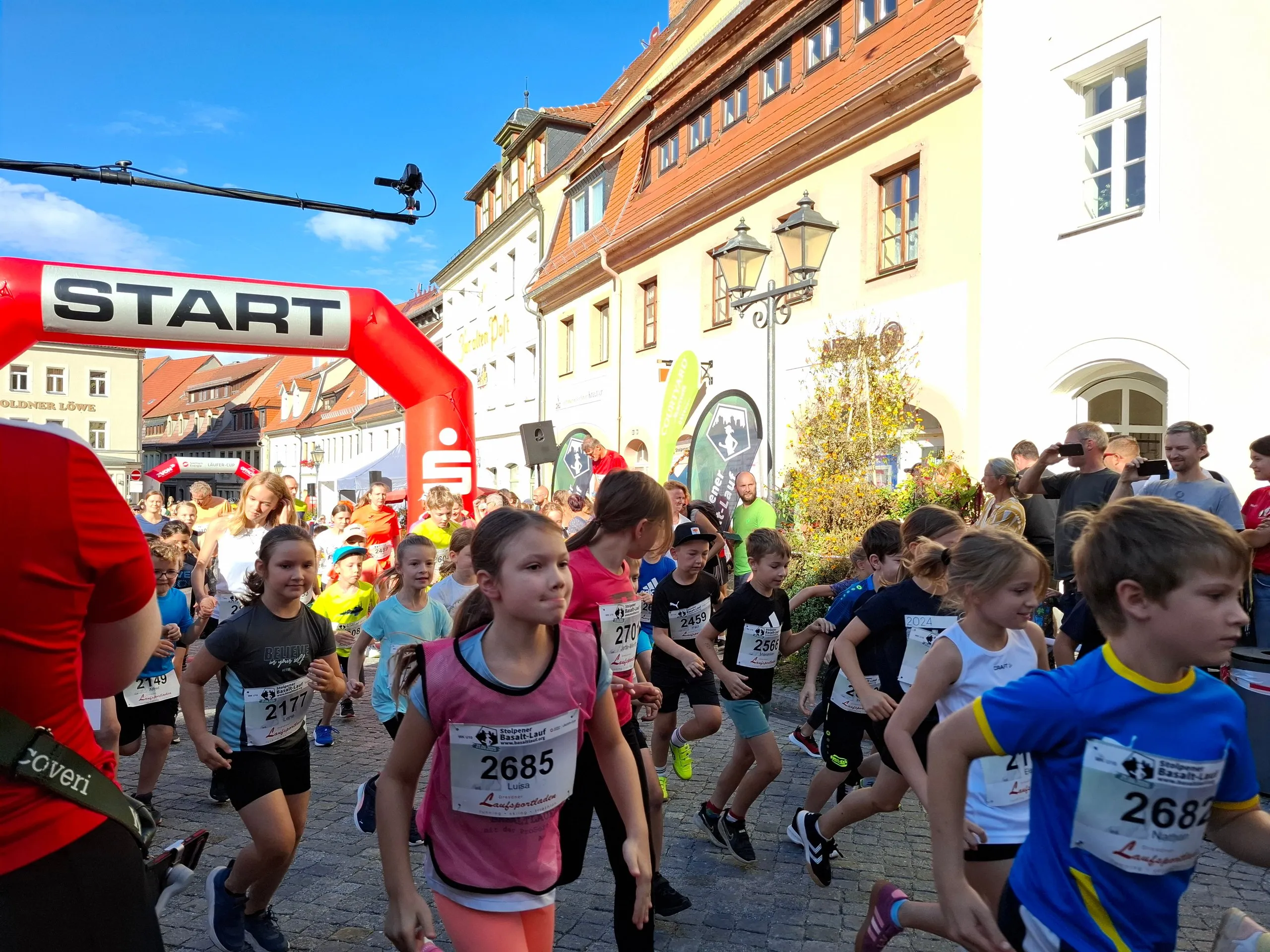 Start eines Kinderlaufs unter dem roten Startbogen auf dem Marktplatz